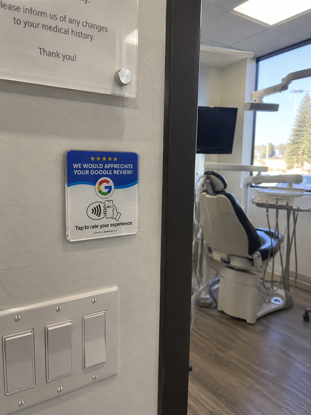Google review plaque mounted on a wall near a dental treatment room